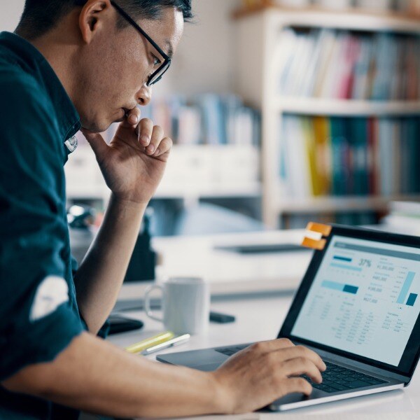 Man looking at computer screen displaying accounting information 