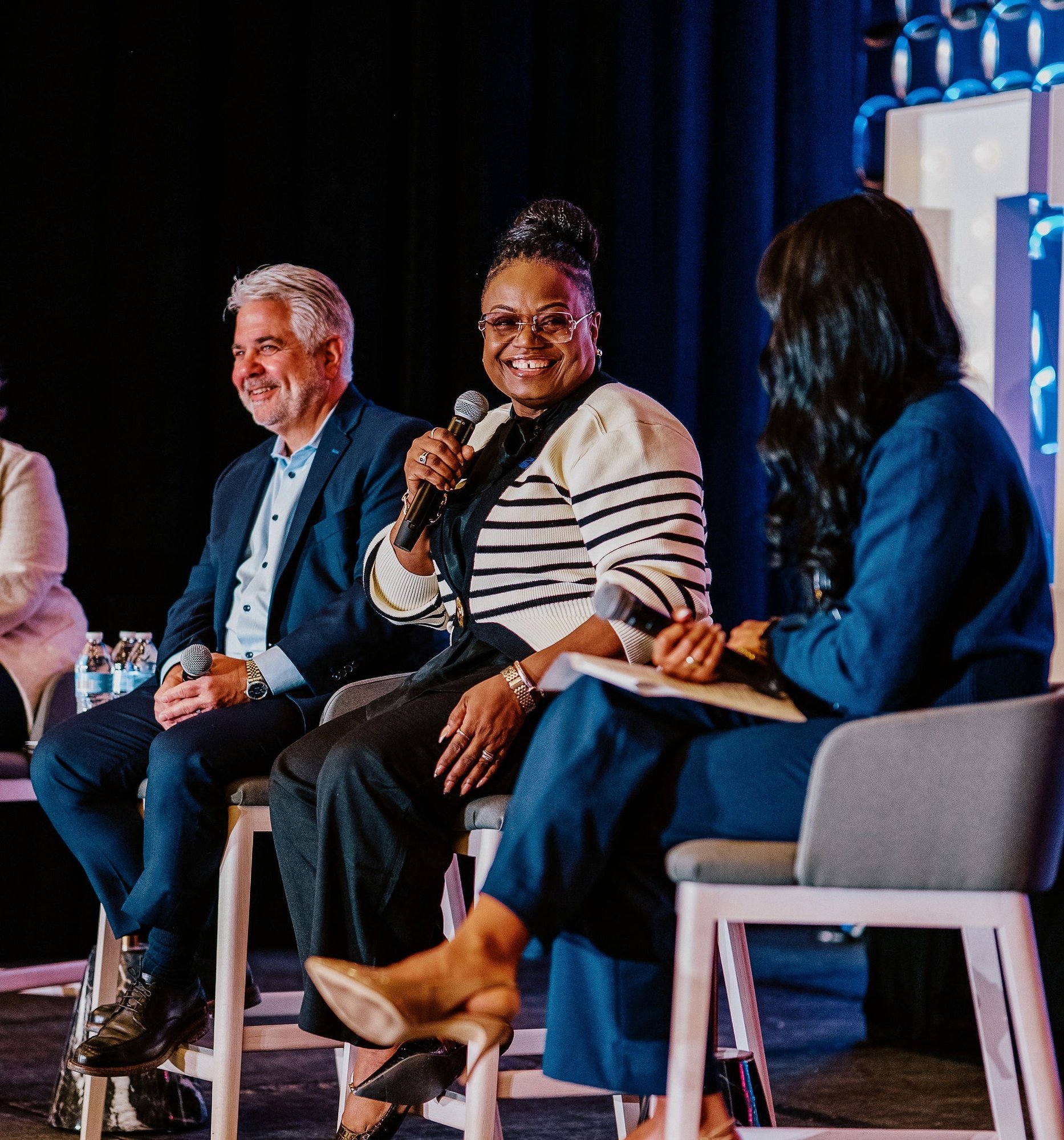 Panel of speakers smiling while presenting at PropertyCon